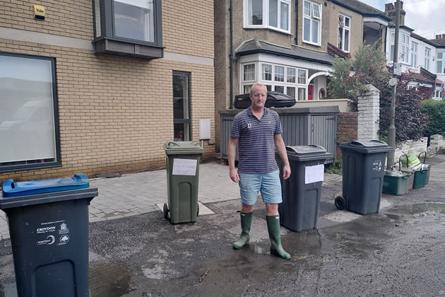 Nick Beazley with signs on his bins warning about the raw sewage
